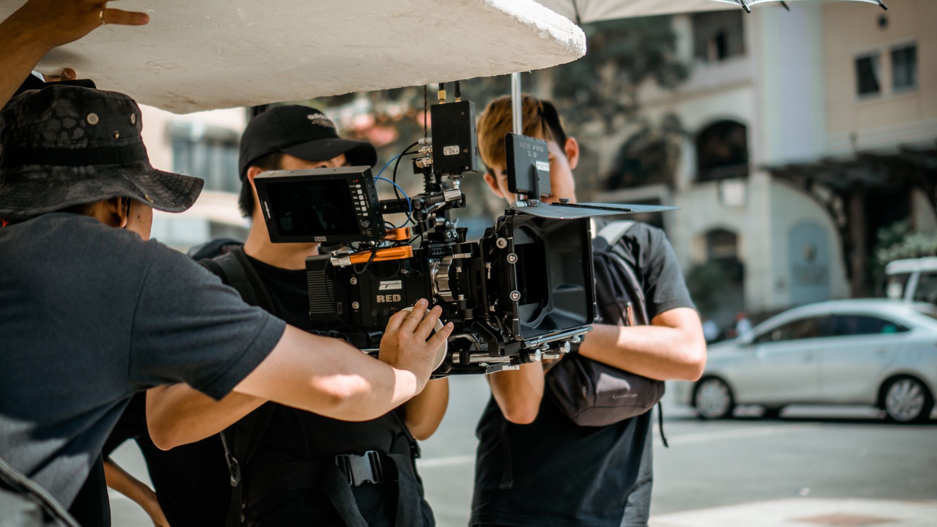 Equipe de filmagem gravando uma cena na rua com câmera profissional